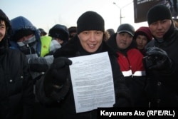 Участник акции протеста показывает требования протестующих. Актау, 19 декабря 2011 года