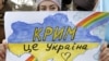 Девушка с плакатом с надписью на украинском языке: «Крым — это Украина» — во время акции в Симферополе против агрессии России, незадолго до аннексии полуострова. 10 марта 2014 года.