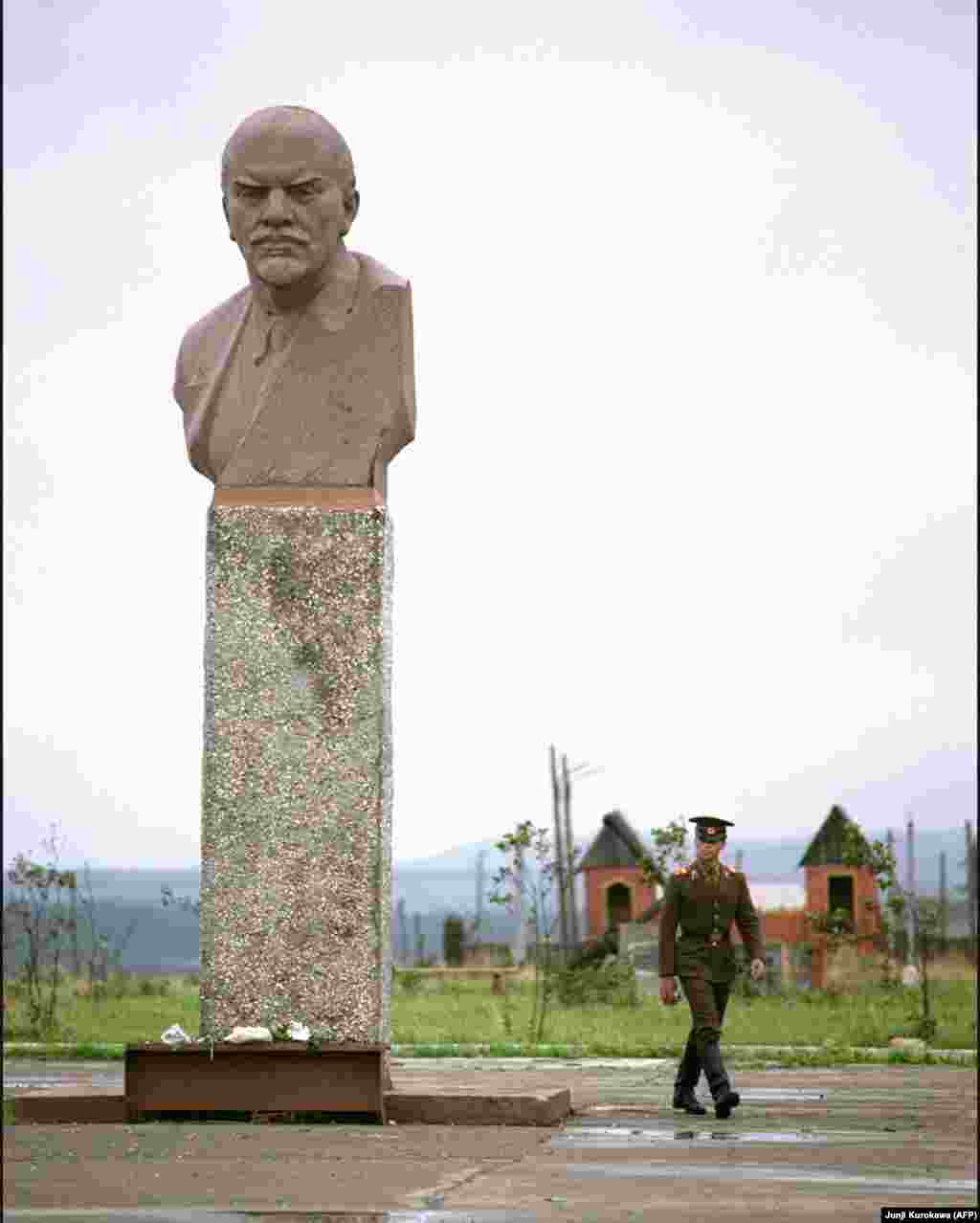 Советский военный на острове Кунашир рядом с памятником Ленину, 1989 год. Вскоре после распада Советского Союза жители Курил провели &laquo;референдум&raquo; - согласны ли избиратели &nbsp;попросить Японию взять острова под свою юрисдикцию. Российский чиновник в телеинтервью возмущенно говорил об этих жителях, инициировавших голосование: &laquo;Большинство этих людей &ndash; никто и ничто&raquo;.